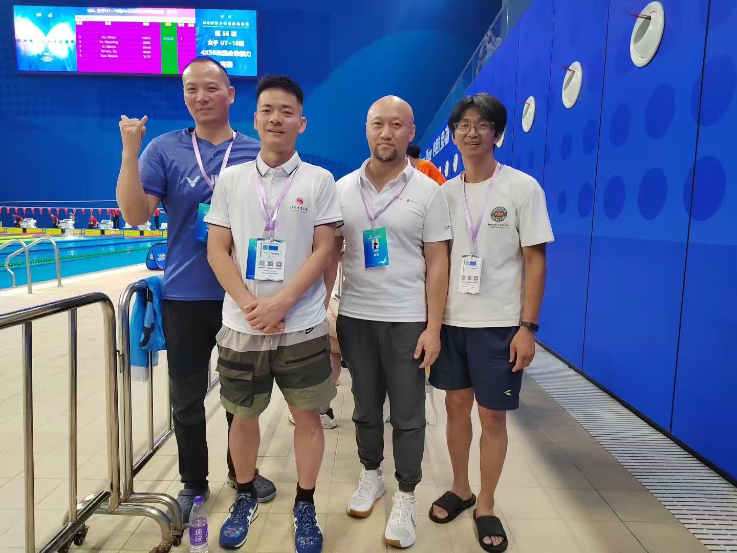 Frank张伟与三位活动参与者在游泳赛事现场合影
