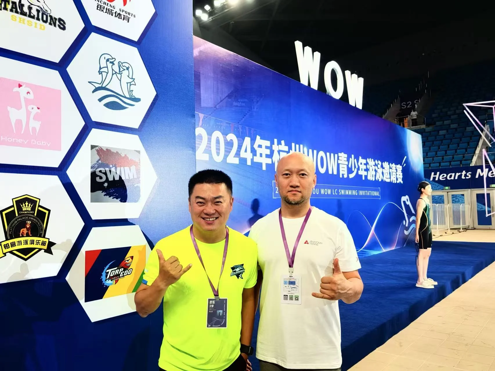 Frank张伟在青少年游泳邀请赛现场与教练合影